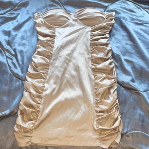 A skin tight strapless beige dress